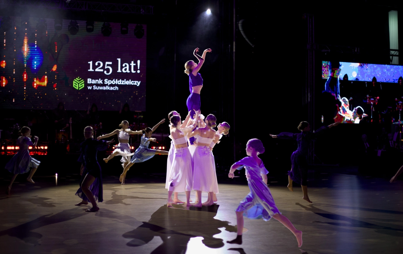 Grupa tancerek wykonuje taniec otwarcia na scenie podczas gali jubileuszowej 125-lecia Banku Spółdzielczego w Suwałkach.